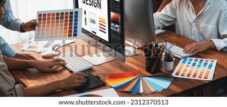 Graphic designer work on computer laptop and with graphic drawing pen while brainstorming unique design with professional graphic team in modern digital studio workplace. Panorama shot. Scrutinize Royalty-Free Stock Photo #2312370513