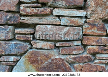 Stone fence or wall of an old building, stone background, out of focus