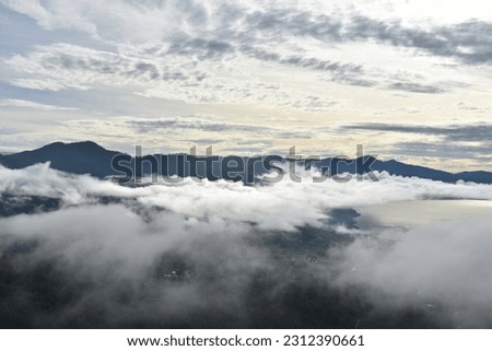 sunrise in the mountains above the clouds. Location of Aceh, Indonesia. Mountains in low clouds at sunrise in summer. Aerial view of mountain peak in fog. 