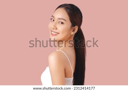 Close up portrait happy young Asian girl with clean and fresh facial skin isolated on pink background.