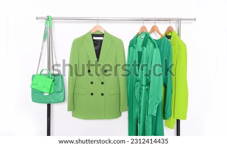 Green clothes, with ,jacket,suit  coat,sweater dress on hanger with handbag Royalty-Free Stock Photo #2312414435