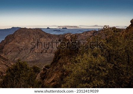 The Pinnacles Look over The Chisos Basin and Foggy Valley Beyond in Big Bend National Park Royalty-Free Stock Photo #2312419039
