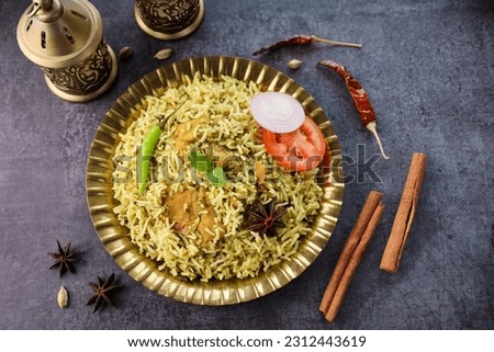 Chicken biryani Spicy Indian Malabar Hyderabadi biryani in golden plate. Dum Biriyani pulao bowl Kerala India Sri Lanka Pakistan basmati rice mixed rice dish with meat curry Ramadan Kareem Eid Royalty-Free Stock Photo #2312443619