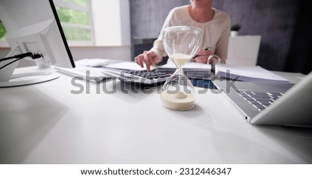 Late Invoice And Billing Deadline With Hourglass At Desk Royalty-Free Stock Photo #2312446347