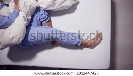 Man With RLS - Restless Legs Syndrome. Sleeping In Bed Royalty-Free Stock Photo #2312447429