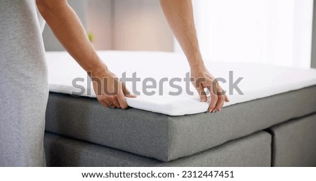 Mattress Topper Being Laid On Top Of The Bed Royalty-Free Stock Photo #2312447451