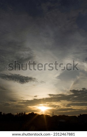 Beautiful sunset - dark sky with clouds and warm sunlight. Stock Photo