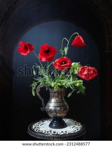 Still life with bouquet of red poppies on a black background