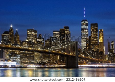 New York City skyline of Manhattan with Brooklyn Bridge and World Trade Center skyscraper at twilight night in the United States