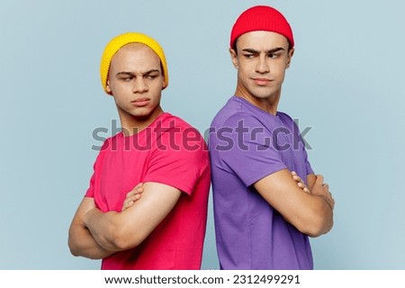 Side view sad young couple two friends men wear casual clothes together hold hands crossed folded look to each other stand back to back isolated on pastel plain blue cyan background studio portrait Royalty-Free Stock Photo #2312499291