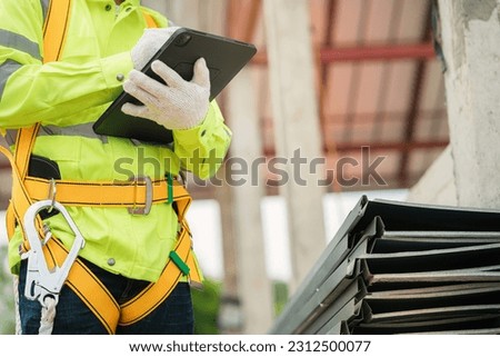 Mechanic engineer checking work on ipad Stay for the house that is not yet finished construction. Royalty-Free Stock Photo #2312500077