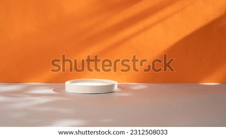 White round concrete podium on orange background with shadows. Mock up for cosmetic products and presentation. Product display.
