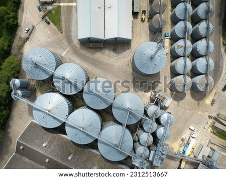 UAV high level view of a large industrial grain silo facility showing rows of storage tanks, drying units etc.