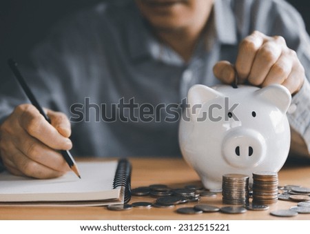 Saving Money Made Simple: Expert Tips for Financial Freedom and Business Success. Unlocking Savings, Investments, and Financial Prosperity. Person put coins into white piggy bank for life saving. Royalty-Free Stock Photo #2312515221