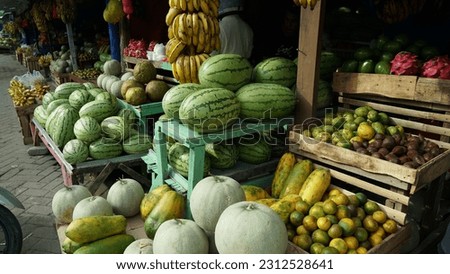 stalls selling fruit in traditional markets. there are bananas, watermelons, dragon fruit, oranges and apples for sale
