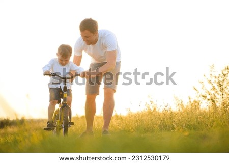 Father help his son ride a bicycle. Royalty-Free Stock Photo #2312530179