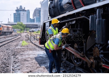Engineer railway wearing safety gear checking train transmittal system for safety travel passenger