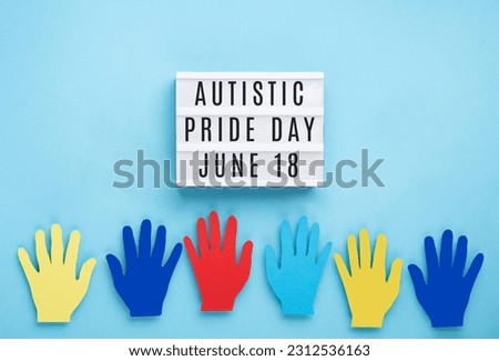Autistic Pride Day or World Autism Awareness Day concept. Creative design for June 18. Colorful hands on blue background, symbol of awareness for autism spectrum disorder. Royalty-Free Stock Photo #2312536163
