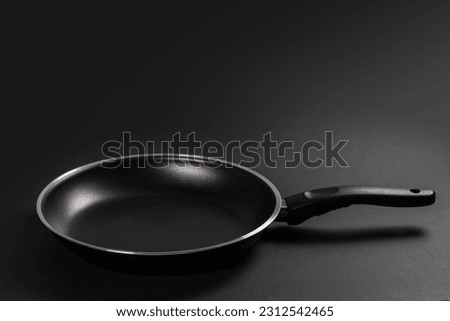 Black fry pan on dark background. close up. Royalty-Free Stock Photo #2312542465