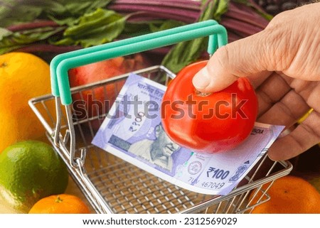 Prices of food, vegetables and fruits in India, Financial concept, Tomato placed in a basket along with a 100 Indian rupees bill