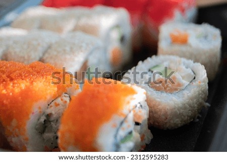 Rolls with rice, fish, cheese and caviar close-up.