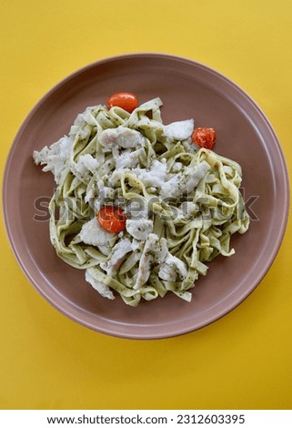 Pesto chicken fettuccini with cherry tomatoes on a plate