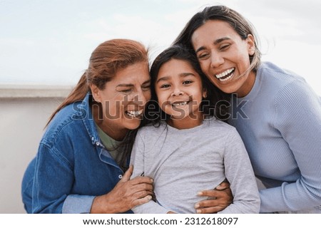Happy latin multi generational family having tender moment together outdoor - Female child smiling on camera 