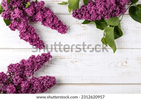 Composition of flowers lilac on a white wooden background with space for text. Flat lay, copy space