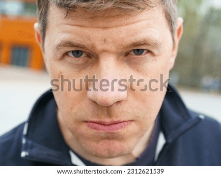 Handsome male model portrair in day outdoors. He has short blond hair. He is so sad. Man is upset about something. Close up great image. He looking at camera Royalty-Free Stock Photo #2312621539
