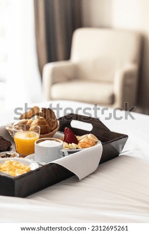 tray of breakfast in bed at a hotel room service vertical Royalty-Free Stock Photo #2312695261