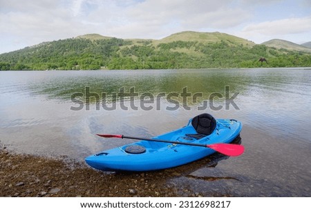 Blue kayak moored at Loch Lomond on island Royalty-Free Stock Photo #2312698217
