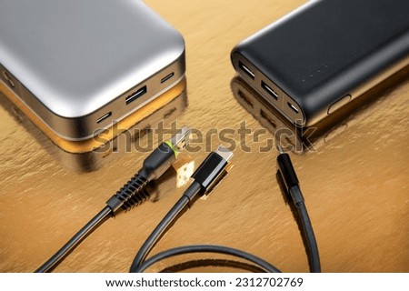 Powerbank portable on a golden background. Electronic devices for charging gadgets and smartphones