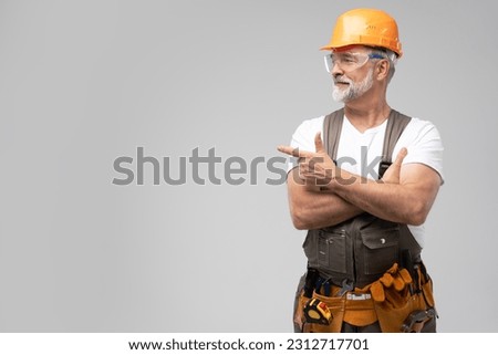 portrait of mature happy handyman presenting something isolated on white background Royalty-Free Stock Photo #2312717701