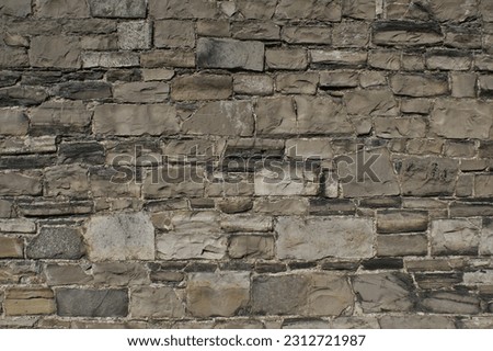 Close-up photo of a wall made of natural stone with a beautiful pattern.