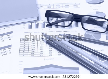 image of color pencils glasses and book on business report