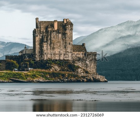 Perched at a captivating viewpoint, the iconic Eilean Donan Castle reveals its enchanting splendor. Surrounded by shimmering waters and nestled amidst rugged landscapes Royalty-Free Stock Photo #2312726069