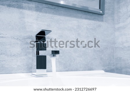 Faucet and water drop close up. Bathroom interior with sink and water tap. Flow water in bathroom with sink.