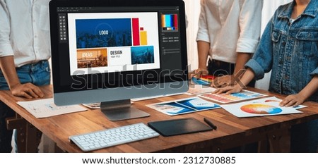 Graphic designer brainstorming logo and graphic art at busy artistic workshop, laptop display workspace. Experimenting color palette and pattern for creative design. Panorama shot. Scrutinize Royalty-Free Stock Photo #2312730885