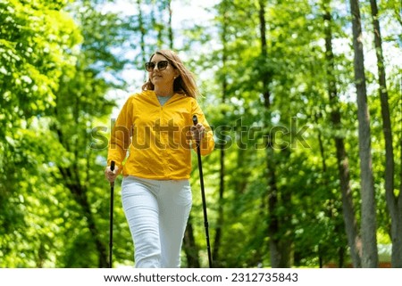 Nordic walking - woman training in city park  Royalty-Free Stock Photo #2312735843