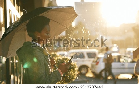 Umbrella, phone and black woman in a city, rain and connection with mobile app, network and chatting. Female person outdoor, weather and girl with a cellphone, contact and communication with cover Royalty-Free Stock Photo #2312737443
