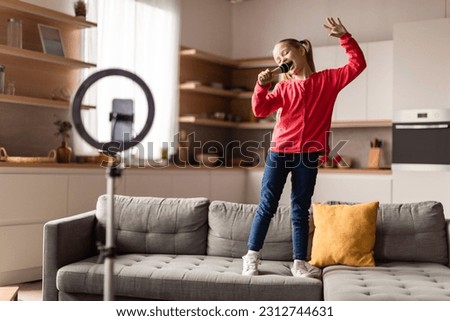 Funny Little Girl Shooting Video For Social Media, Singing And Dancing At Home, Cheerful Preteen Female Child Holding Microphone, Capturing Content With Smartphone And Selfie Circle