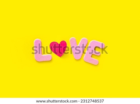 Pink Love text isolated on yellow background with copy space. Valentines day greeting card template. Minimalism concept.