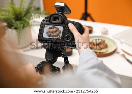 Food stylist taking photo of delicious meat medallion in studio, closeup