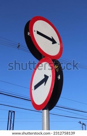 Road signs with clear blue sky in the background.