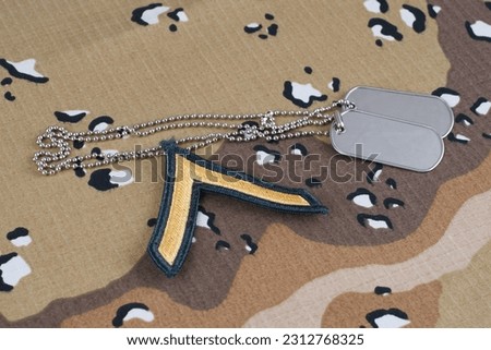US ARMY Private rank patch and dog tags on desert camouflage uniform background
