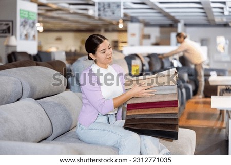 Woman deciding on material for couch in furniture store