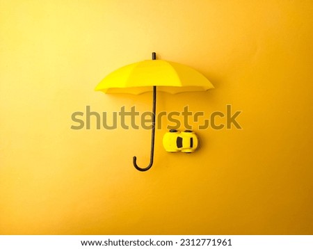 Yellow umbrella covered yellow car on a yellow background