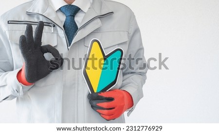 A Japanese beginner mark and a man in work clothes. Royalty-Free Stock Photo #2312776929