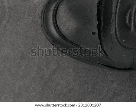 Black shoes that have been damaged and peeling leather