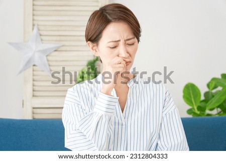 Asian woman with rhinitis at home Royalty-Free Stock Photo #2312804333